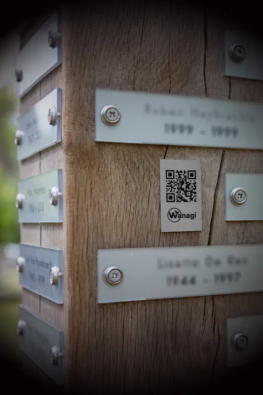 Roestvrij stalen Wanagi QR gedenkplaat bevestigd op een houten gedenkzuil